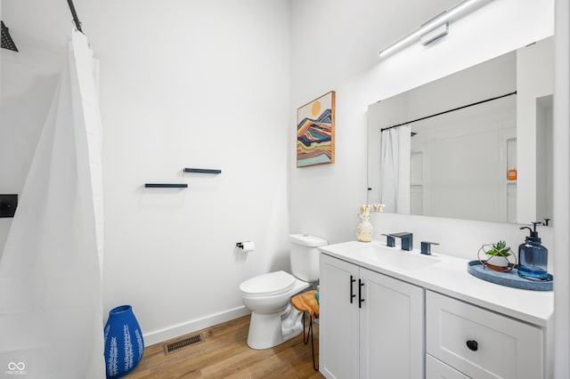 bathroom with toilet, hardwood / wood-style floors, curtained shower, and vanity