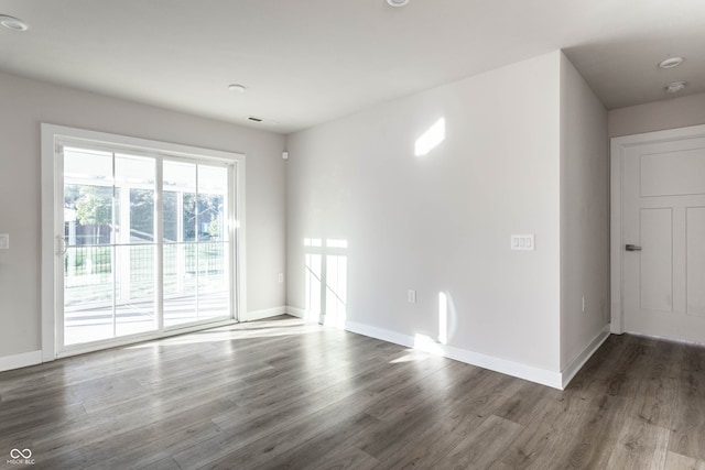 unfurnished room with dark wood-type flooring