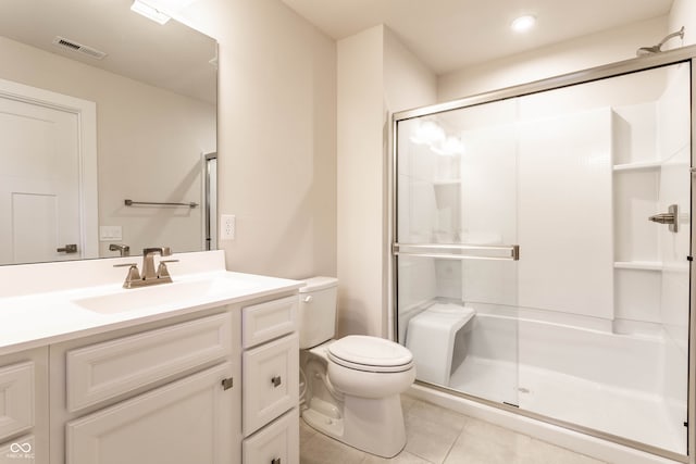 bathroom with tile patterned flooring, vanity, toilet, and walk in shower