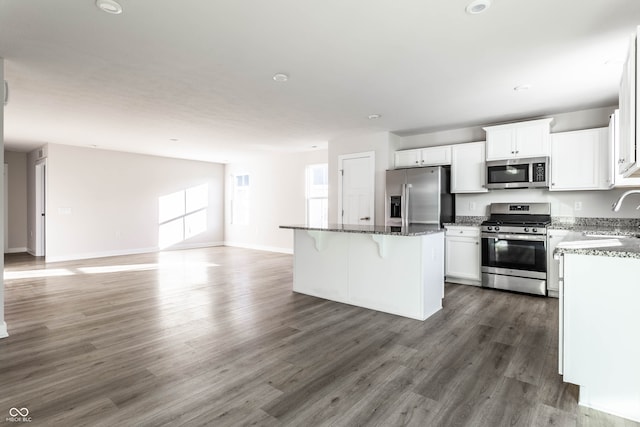 kitchen featuring a wealth of natural light, a center island, white cabinets, and appliances with stainless steel finishes