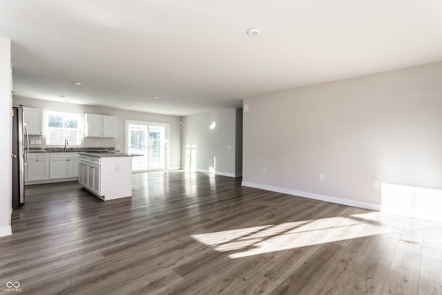 unfurnished living room featuring sink and dark hardwood / wood-style floors