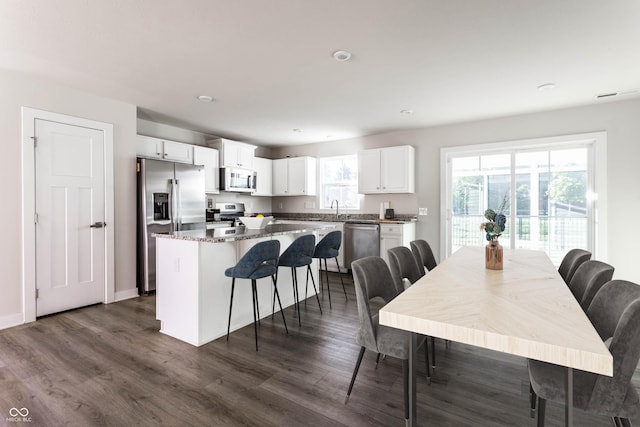 dining room with a healthy amount of sunlight, dark hardwood / wood-style flooring, and sink