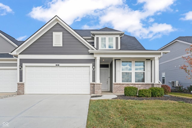 craftsman inspired home with a garage and a front lawn