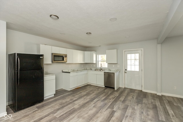 kitchen featuring white cabinetry, appliances with stainless steel finishes, and light hardwood / wood-style flooring