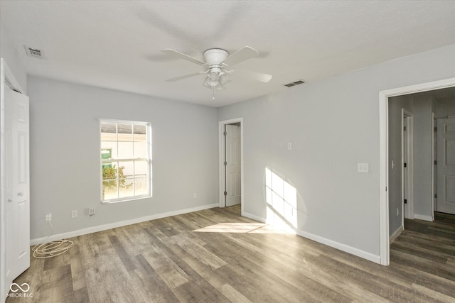 unfurnished bedroom featuring hardwood / wood-style floors, ceiling fan, and a textured ceiling