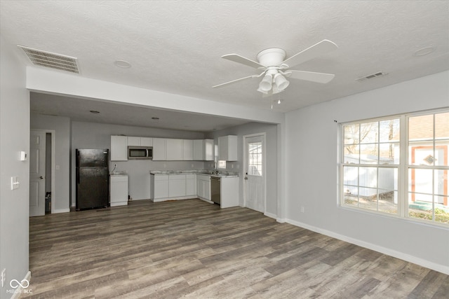 unfurnished living room with a wealth of natural light, ceiling fan, light hardwood / wood-style floors, and a textured ceiling