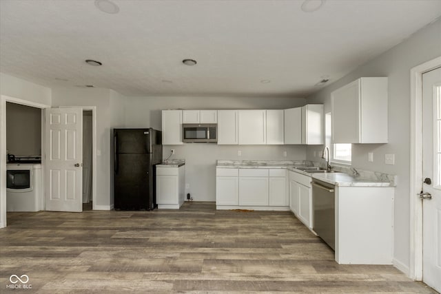 kitchen with white cabinetry, sink, hardwood / wood-style flooring, and appliances with stainless steel finishes