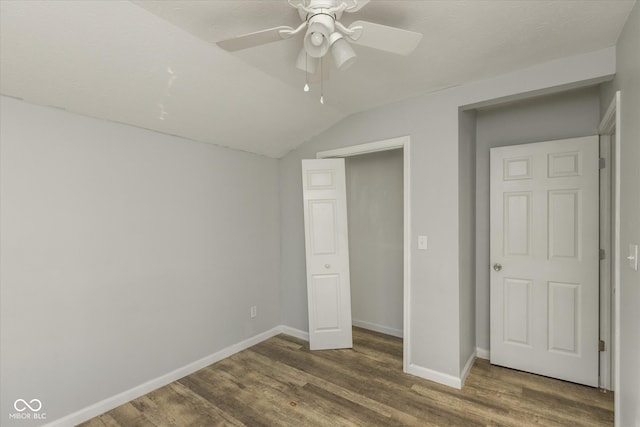 unfurnished bedroom featuring lofted ceiling, ceiling fan, and dark wood-type flooring