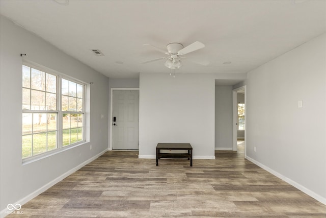 empty room with ceiling fan and light wood-type flooring