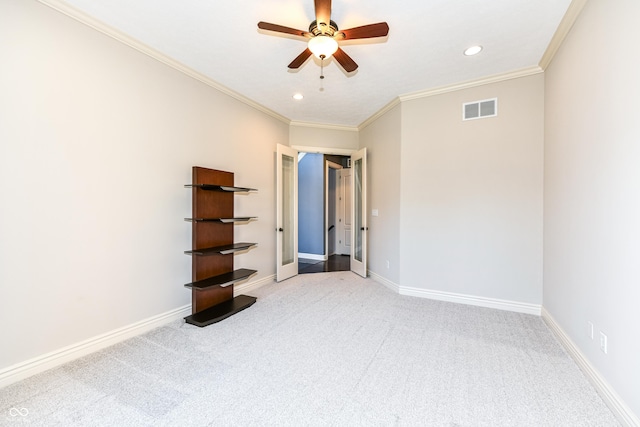 unfurnished bedroom with ceiling fan, light colored carpet, and crown molding