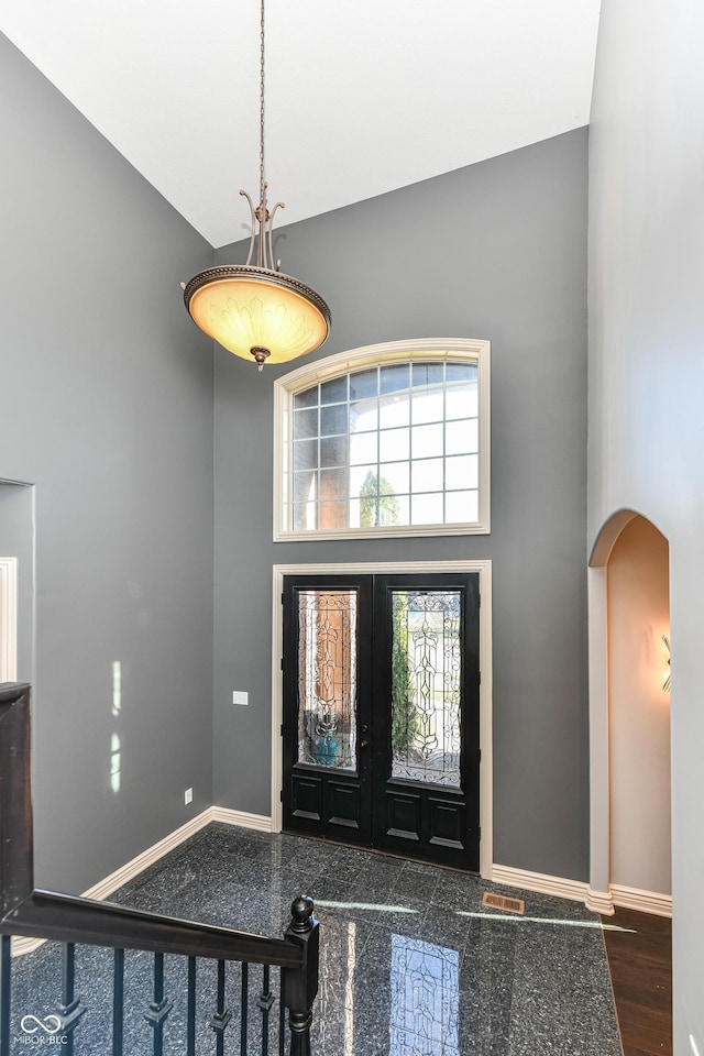 entryway with dark hardwood / wood-style flooring, high vaulted ceiling, and french doors