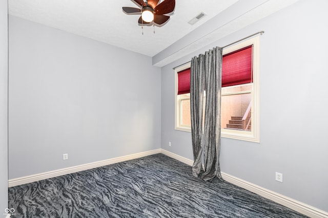 carpeted spare room featuring ceiling fan