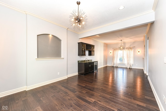 unfurnished living room with dark hardwood / wood-style floors, crown molding, and a notable chandelier