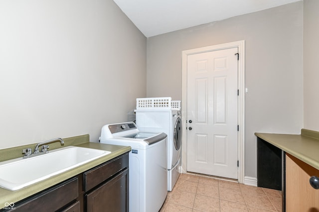 washroom with cabinets, washing machine and dryer, light tile patterned flooring, and sink