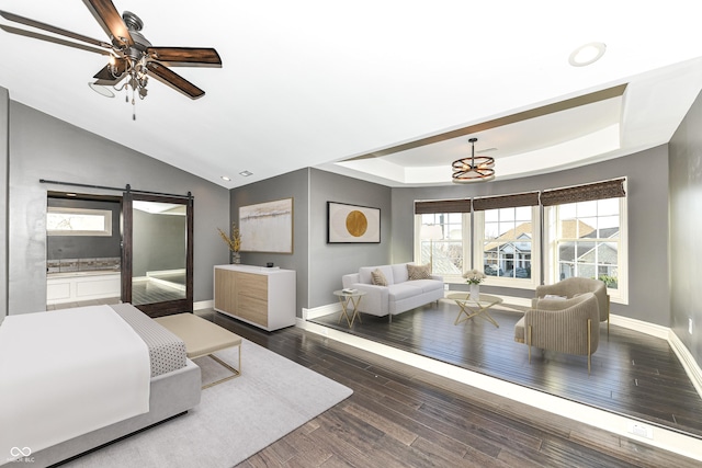 bedroom featuring ceiling fan, a barn door, dark hardwood / wood-style flooring, and vaulted ceiling