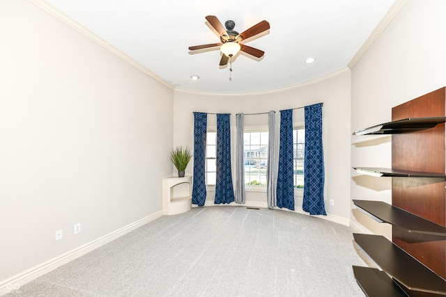 spare room featuring light carpet, ceiling fan, and ornamental molding