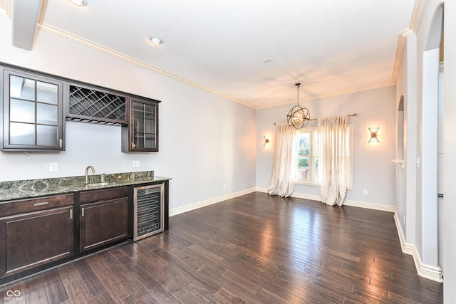 interior space with dark hardwood / wood-style floors, dark stone countertops, decorative light fixtures, dark brown cabinetry, and beverage cooler