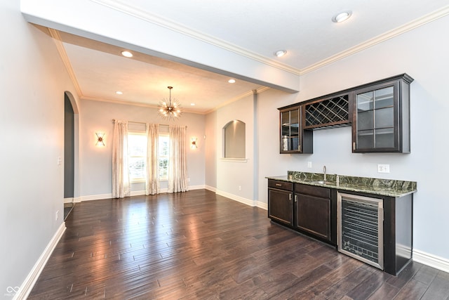 bar with sink, wine cooler, dark hardwood / wood-style floors, crown molding, and dark stone counters