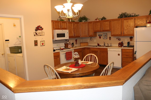 kitchen featuring white appliances, sink, wood counters, hanging light fixtures, and a notable chandelier