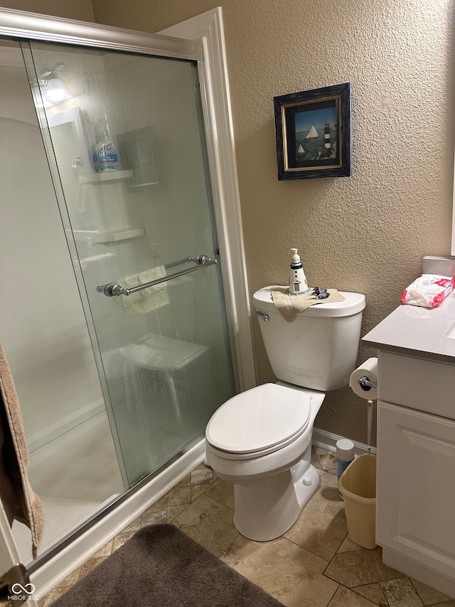 bathroom featuring vanity, an enclosed shower, toilet, and tile patterned flooring