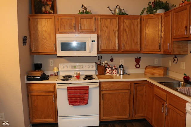 kitchen featuring white appliances, sink, and dark hardwood / wood-style flooring