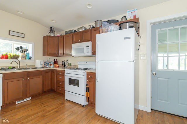 kitchen with white appliances, light wood-type flooring, and plenty of natural light