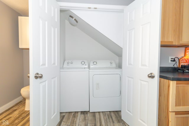 clothes washing area with independent washer and dryer and wood-type flooring