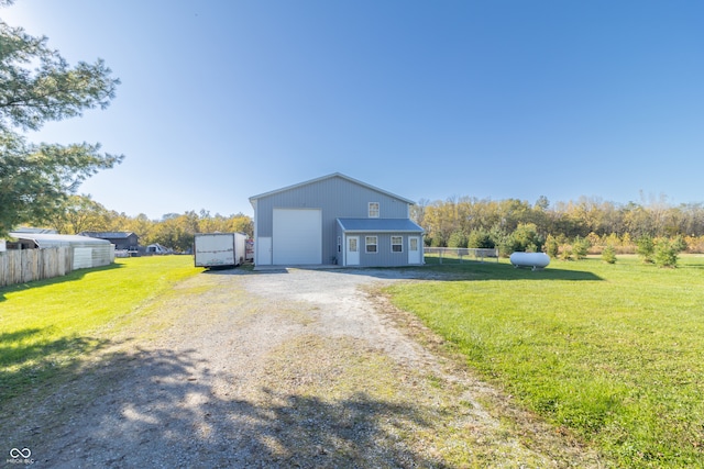 view of front of house with a front yard, an outbuilding, and a garage