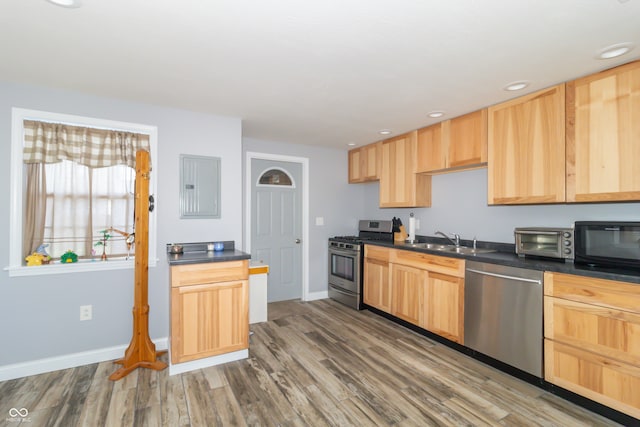 kitchen with sink, hardwood / wood-style floors, stainless steel appliances, electric panel, and light brown cabinets