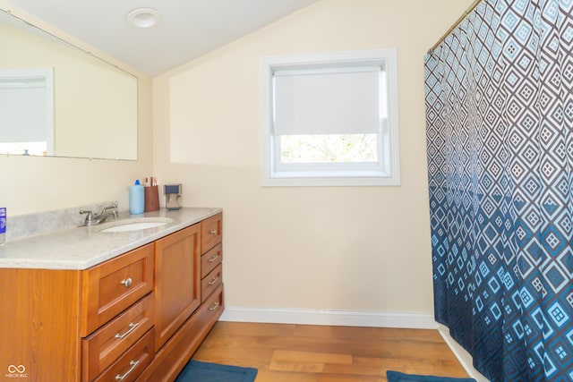 bathroom featuring vanity, lofted ceiling, and hardwood / wood-style flooring