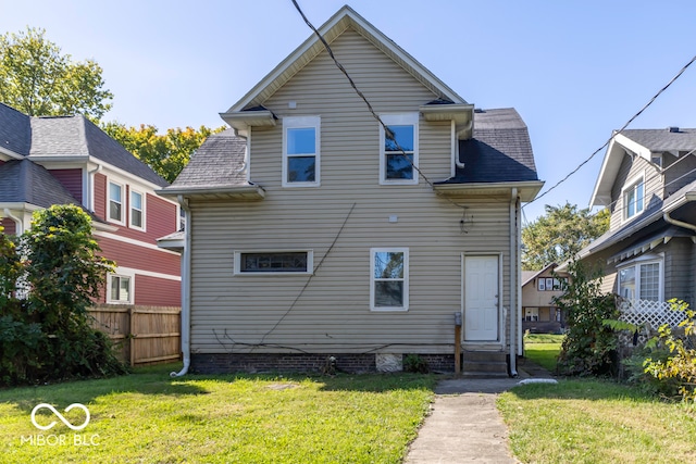 rear view of house featuring a yard