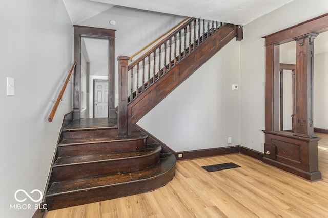 staircase with hardwood / wood-style floors