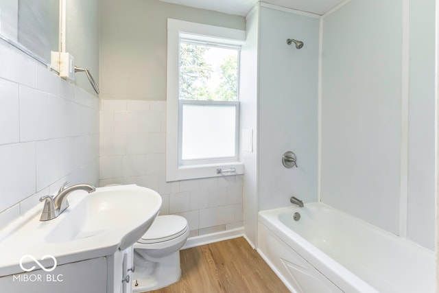 full bathroom featuring toilet, shower / bathtub combination, vanity, hardwood / wood-style floors, and tile walls