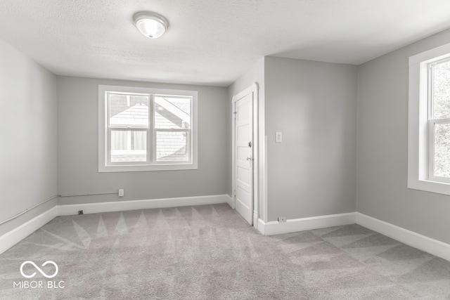 carpeted spare room with a textured ceiling