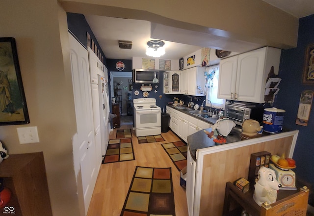 kitchen featuring light hardwood / wood-style flooring, kitchen peninsula, sink, white cabinets, and white appliances