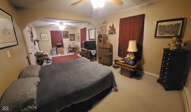 carpeted bedroom with a baseboard heating unit and ceiling fan