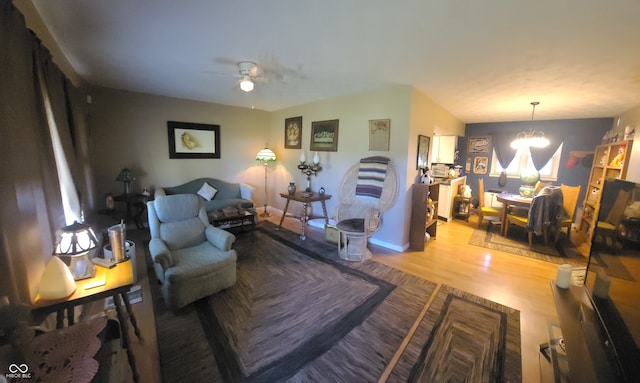 living room featuring light hardwood / wood-style flooring and ceiling fan with notable chandelier