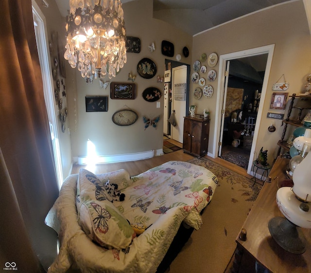 bedroom featuring wood finished floors, baseboards, and an inviting chandelier