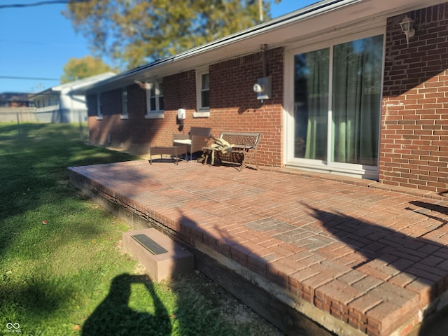 wooden terrace featuring a patio area and a lawn