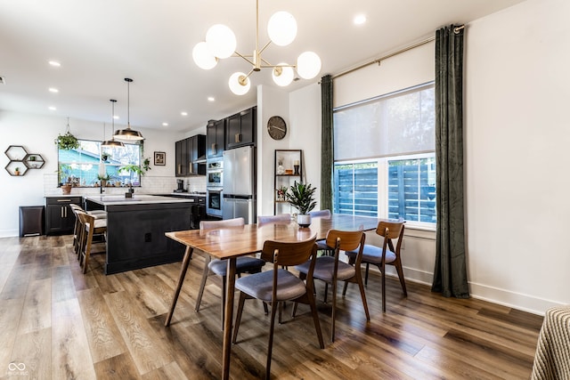 dining area with an inviting chandelier and light hardwood / wood-style flooring