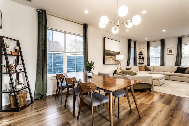 dining room featuring an inviting chandelier, wood-type flooring, and plenty of natural light