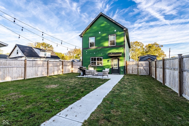 rear view of property with a patio and a lawn