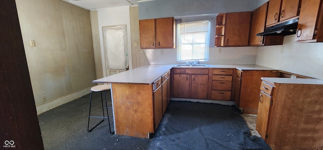 kitchen with kitchen peninsula, sink, and a breakfast bar area