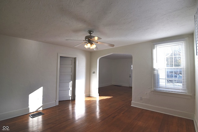 empty room featuring a textured ceiling, dark hardwood / wood-style flooring, and ceiling fan