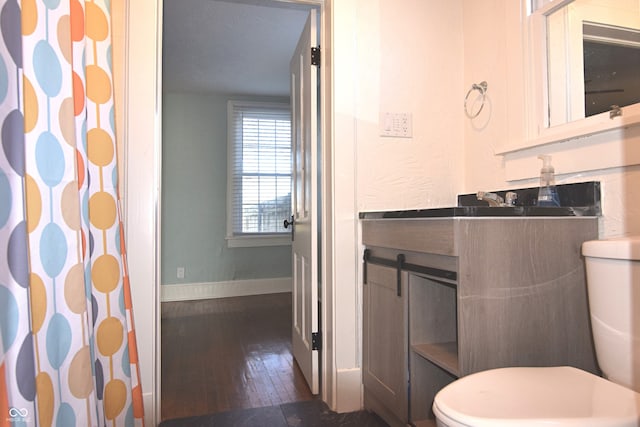 bathroom featuring toilet, wood-type flooring, and walk in shower