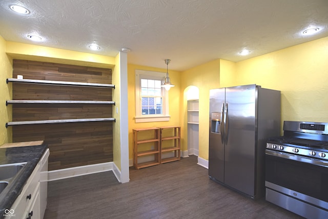 kitchen with stainless steel appliances, dark hardwood / wood-style floors, a textured ceiling, decorative light fixtures, and white cabinets