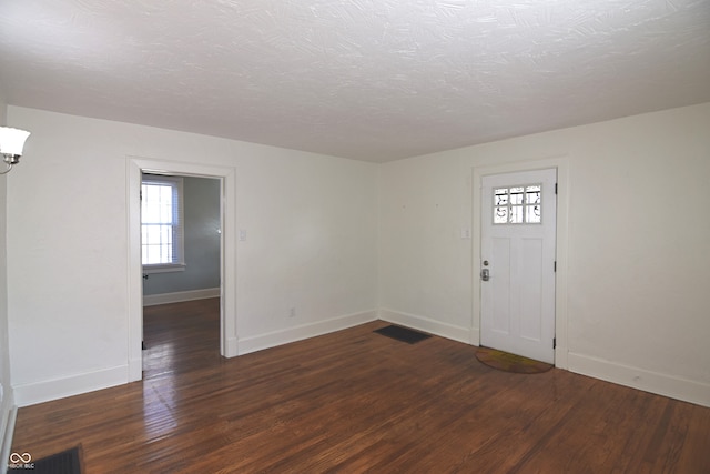 entryway with a textured ceiling and dark hardwood / wood-style floors