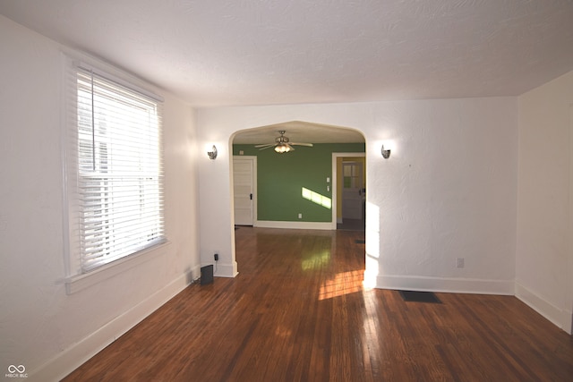 unfurnished room featuring a textured ceiling, dark hardwood / wood-style flooring, and ceiling fan