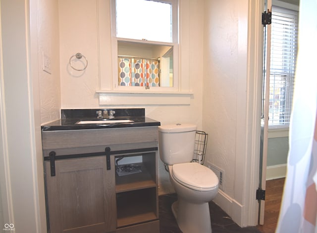 bathroom featuring hardwood / wood-style flooring, vanity, and toilet