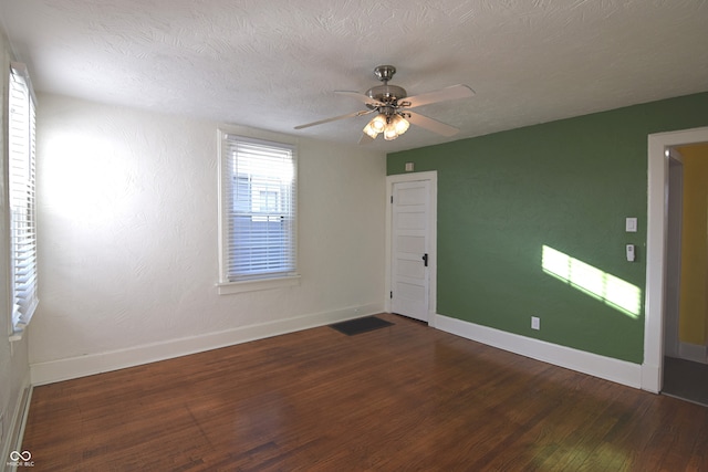 unfurnished room with a textured ceiling, ceiling fan, and dark hardwood / wood-style floors